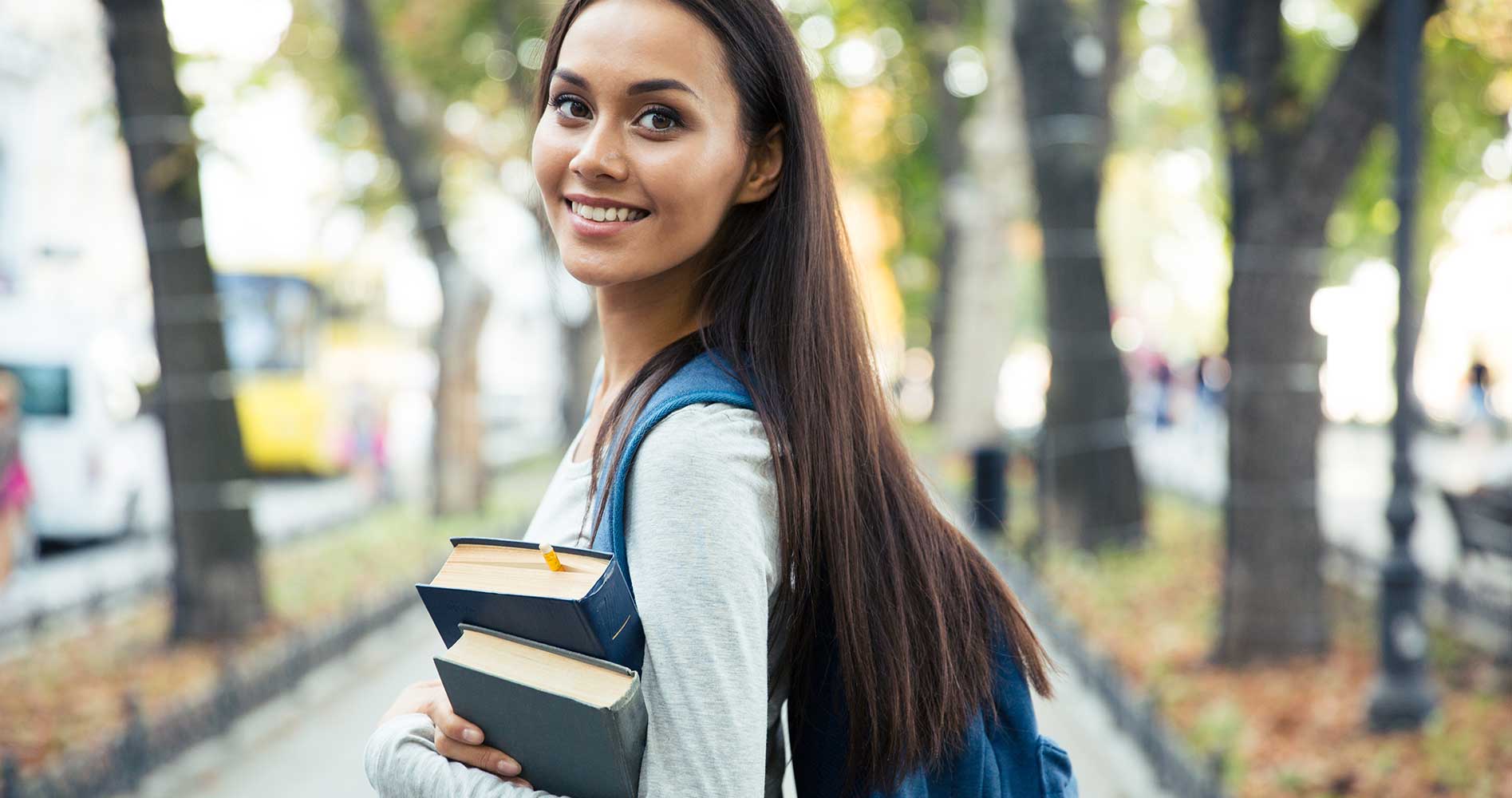 female uni student holding text books